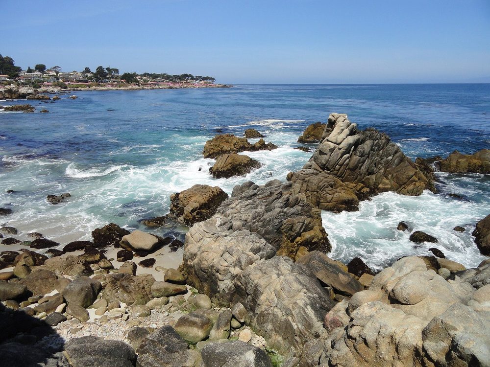 Granite rocks, tide pools, and the Pacific Grove shoreline at Lovers Point on a clear day